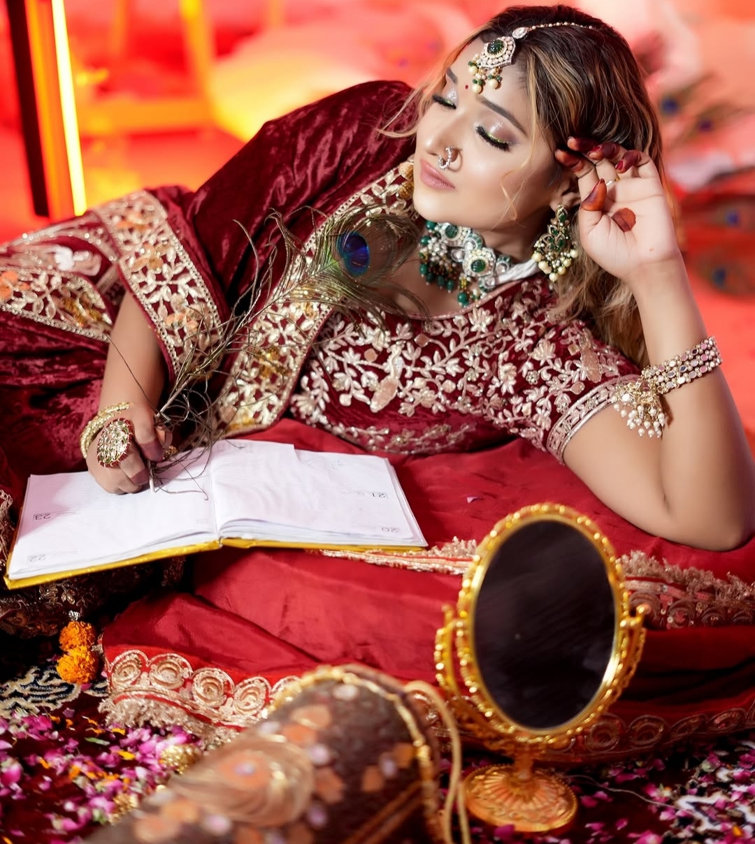 a women in red with eyes closed wearing jewellery and makeup , posing elegantly
