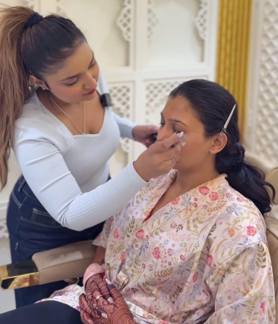 a women makeup artist doing makeup on her client with dedication