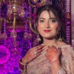 a women in silky sarree with makeup and jewellery posing
