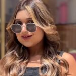 a girl with wearing shades and have brown hair posing