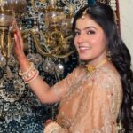 happy women wearing golden sarree with makeup and jewellery, posing