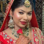 women in red with makeup and jewellery and carring rose in hands posing