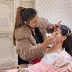 a happy makeup artist doing makeup on her client