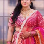 a women in colourful lehenga with makeup on face and worn jewellery , posing