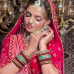 a women in red bridal wear and wearing jewellery posing