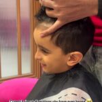 a small child boy with happiness on face getting his haircut