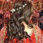 a women showing her curls hairstyle and in hairs there is accessory
