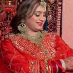 a women in red bridal wear and wearing bridal jewellery and also makeup on face