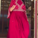 a women wearing red dress with makeup on face walking down stairs
