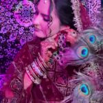 a beautiful women posing and wearing red bridal wear and background have purple lightning with luxury background