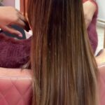 women flaunting her smooth ,silky ,straight hair with brown highlights