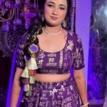 a women with makeup on face in purple lehenga posing