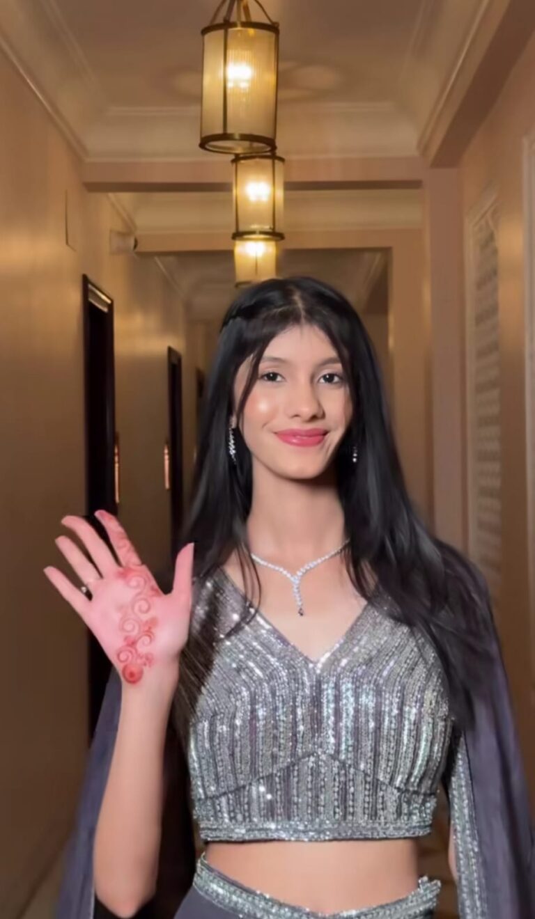 a girl worn grey coloured lehenga , smiling and looking at the camera
