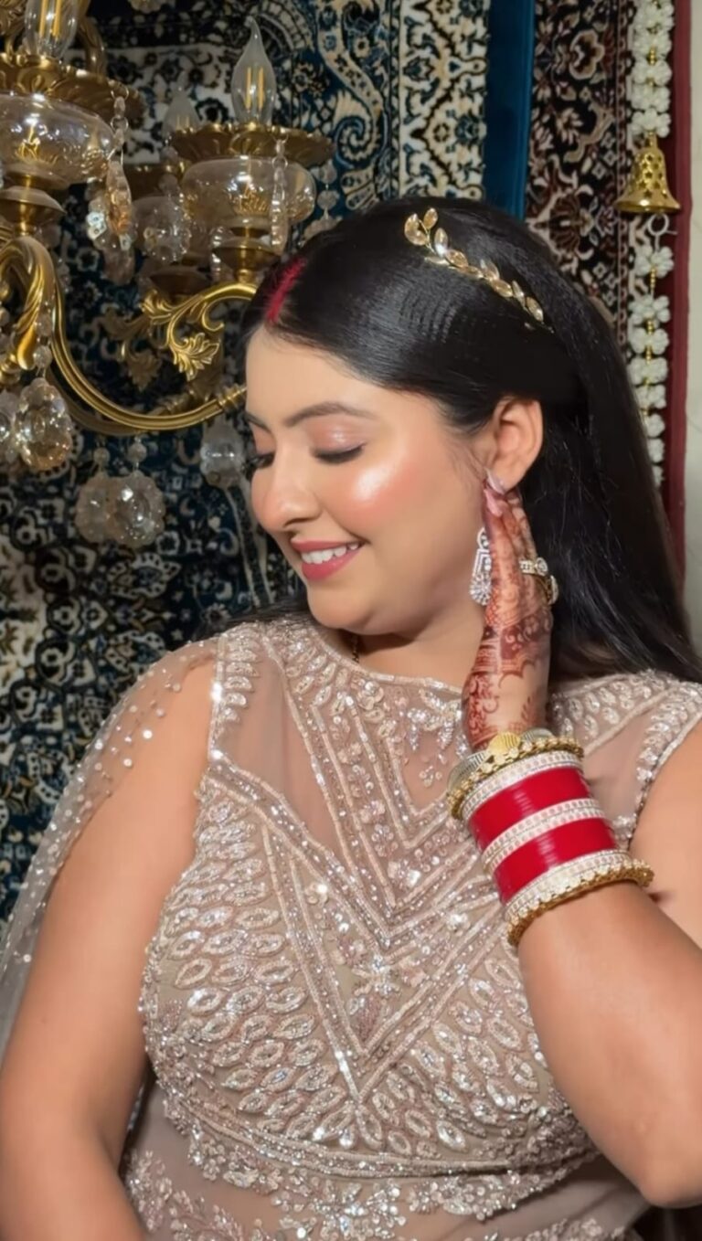 a women doing side pose , worn skin colour dress and also worn makeup and jewellery